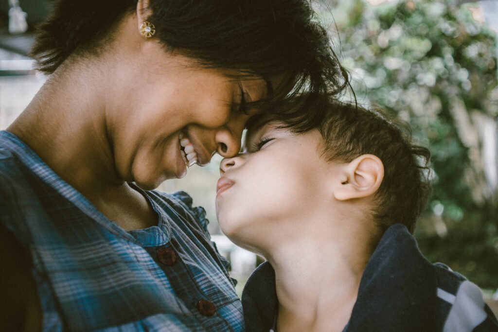 Smiling mother and elementary aged son touch foreheads